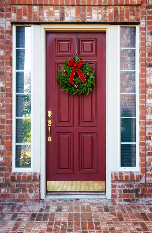 adding a wreath to your front door for Christmas decorating