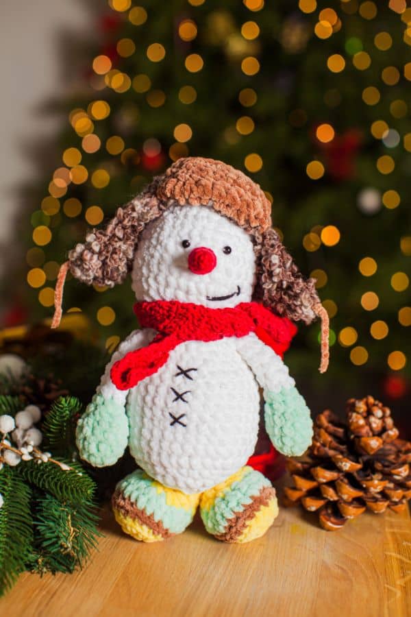 crocheted snowman with a winter hat on his head