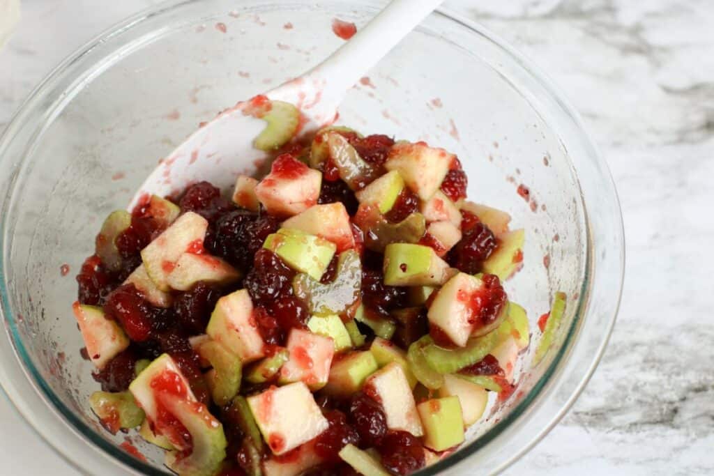 clear bowl of freshly mixed apple and cranberry salad