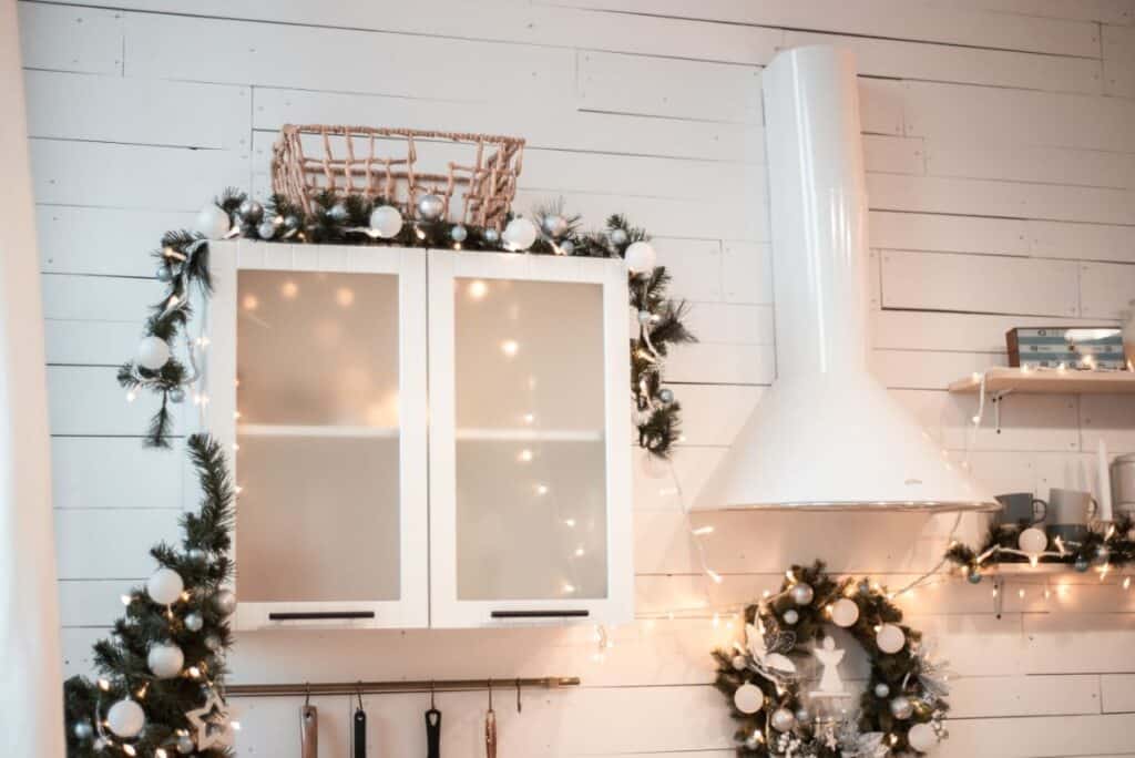 greenery on top of white kitchen cabinet with fairy lights