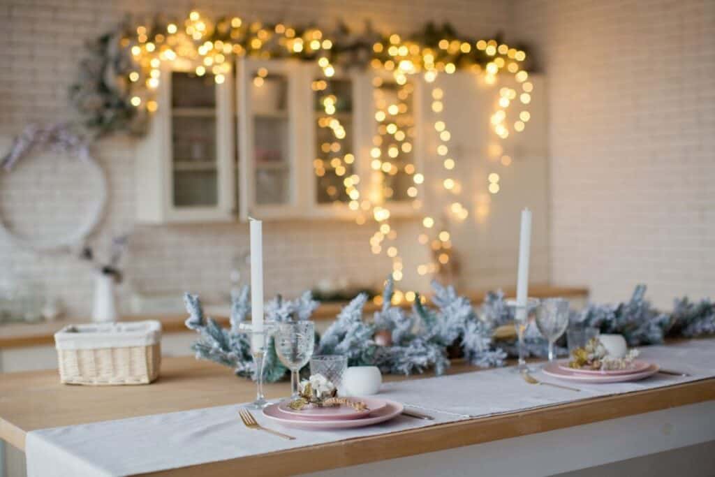 countertop in kitchen decorated for Christmas with lights and greenery