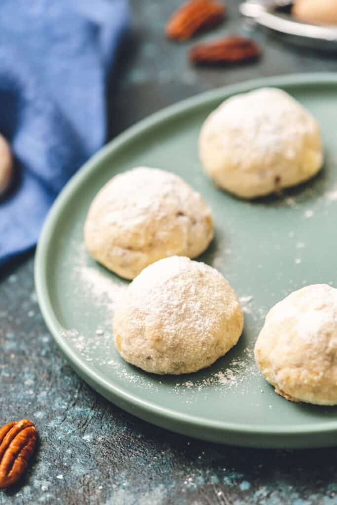 4 pieces of snowball cookies on a plate