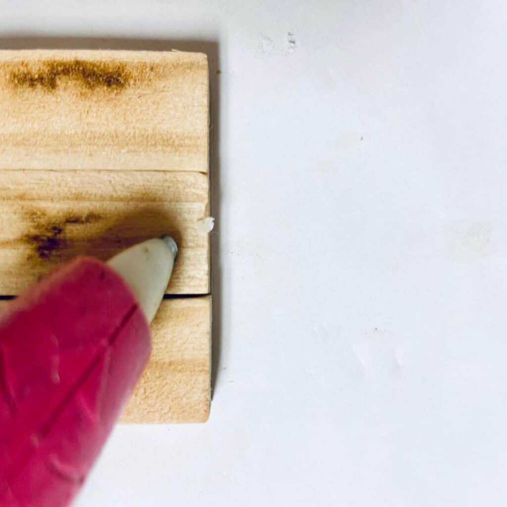 Placing hot glue on jenga pieces