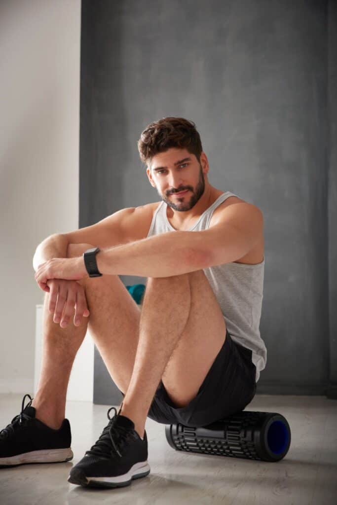 man sitting on a foam roller