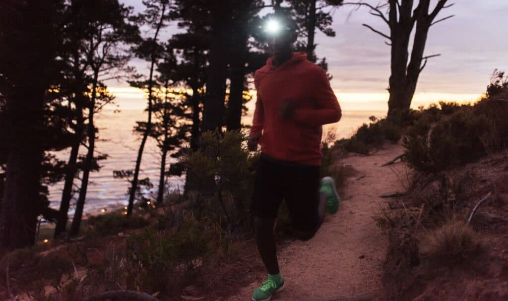 man running at desk with headlamp on